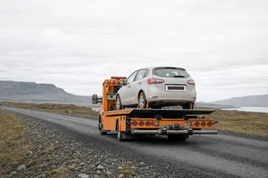 Dráttarbíll flytur ökutæki á íslenskum þjóðvegi